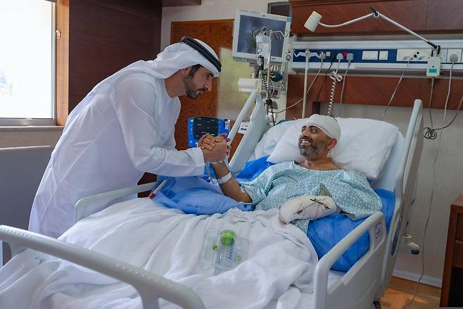 아랍에미리트(UAE) 아부다비의 한 병원에서 셰이크 함단 빈 무함마드 빈 라시드 알막툼 두바이 왕세자(왼쪽)가 부상을 입은 인도 국적의 플라이두바이 소속 스미트 마차르 기장을 위문하고 있다. [AP]