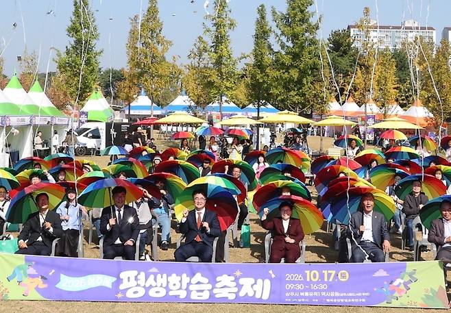 ▲ 10월 17일부터 18일까지 상주시립도서관에서 열린 '2026 상주 만화·웹툰 페스티벌' 개회식에서 안창수 상주시의회 의장, 임이자 국회의원(국민의힘, 상주문경), 안재민 상주시장(앞줄·오른쪽·두번째부터), 시민 등이 오색 우산을 쓰고 개회식 퍼포먼스를 펼치고 있다. 상주시 제공