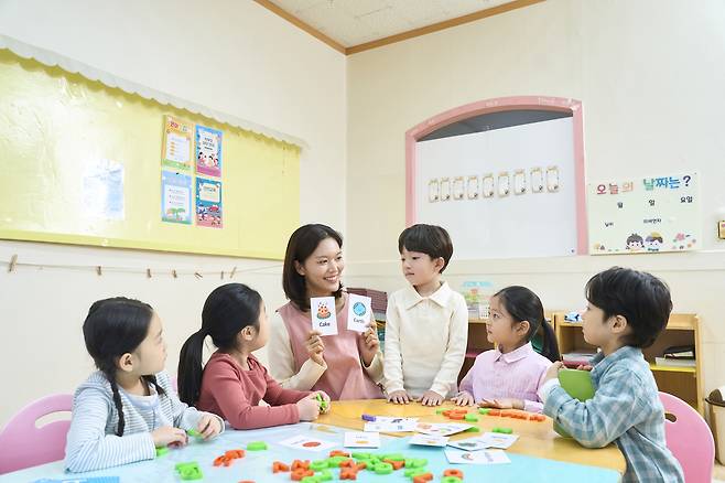 서울 시내의 한 어린이집에서 보육교사가 원아들과 함께 단어 카드 놀이 수업을 진행하고 있다. 최근 저출생에 따른 영아반 축소와 연쇄 폐원으로 전국 어린이집 입소 대기 기간이 크게 늘어나면서 맞벌이 학부모들의 돌봄 부담이 커지고 있다. 게티이미지뱅크