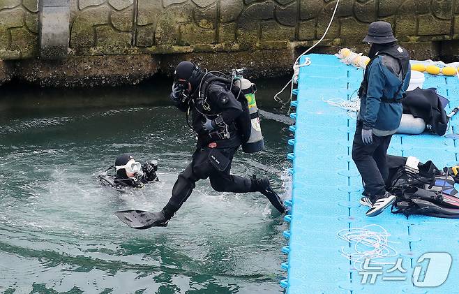 21일 부산 동구 북항 친수공원 인공수로에서 한 달 넘게 머무르고 있는 상어 '부캉이'를 바다로 돌려보내기 위한 3차 외해 유도 작업이 진행되고 있는 가운데 잠수사들이 바다 속으로 뛰어들고 있다. 2026.10.21 ⓒ 뉴스1 윤일지 기자