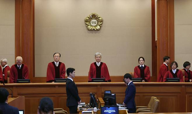김상환 헌법재판소장과 헌법재판관들이 21일 서울 종로구 헌법재판소 대심판정에서 열린 ‘압수수색 영장사본 미교부’ 재판소원 변론을 위해 입장하고 있다. 연합뉴스