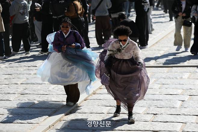 북서쪽에서 찬 공기가 유입되고 강한 바람이 불어 쌀쌀한 날씨를 보인 지난 21일 서울 종로구 경복궁에서 외국인 관광객들이 바람에 날리는 한복 치마를 붙잡고 있다. 문재원 기자