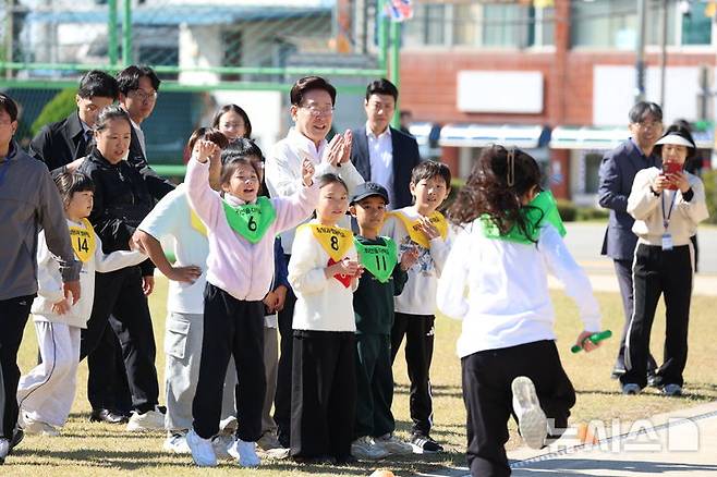[익산=뉴시스] 김진아 기자 = 이재명 대통령이 22일 전북 익산 왕궁초등학교에서 열린 가을 행복학교 체육한마당에서 이어달리기 결승선 테이프를 잡고 학생들을 응원하고 있다. 2026.10.22. bluesoda@newsis.com