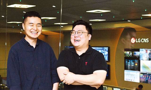LG CNS 문동혁(왼쪽) 팀장과 김병각 팀장이 최근 서울 마포구 상암동 LG CNS 상암IT센터에서 AI 데이터센터 관련 설명을 하며 환하게 웃고 있는 모습. 두 사람은 AI 데이터센터의 전력·냉각 시스템 등 핵심 인프라를 구축하는 업무를 맡고 있다. 권현구 기자