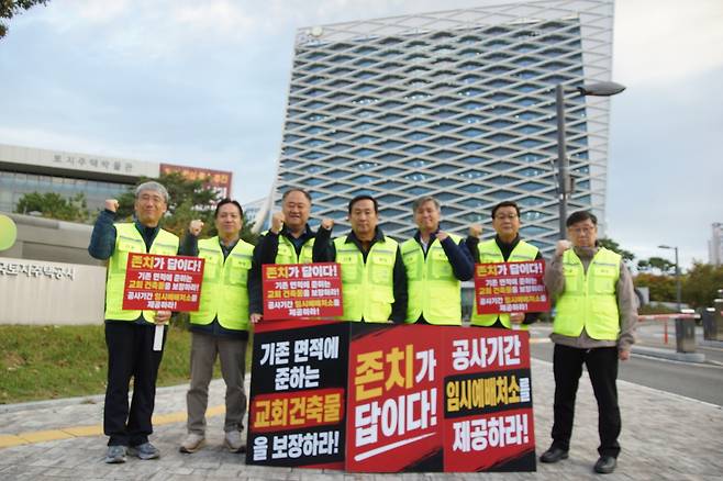 화성진안공공택지지구 교회협의회 장세욱(가운데) 대표회장과 소속 목회자들이 23일 오전 경남 진주시 충의로 한국토지주택공사(LH) 본사 정문 앞에서 피켓을 들고 파이팅을 외치고 있다.