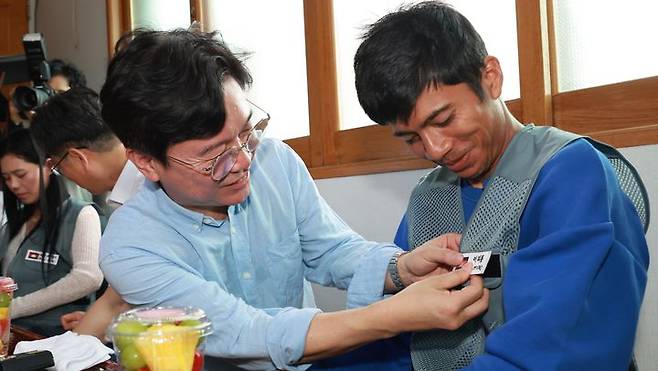 [서울=뉴시스] 김영훈 고용노동부 장관이 지난해 8월8일 전북 완주군의 외국인 고용 농가를 방문해 간담회에 앞서 외국인 노동자에게 한글 이름표를 붙여주고 있는 모습. (사진=고용노동부 제공) 2025.08.08. photo@newsis.com *재판매 및 DB 금지