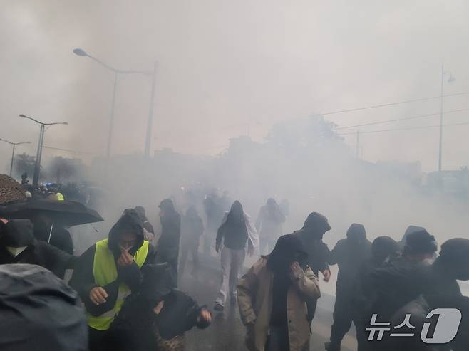 (파리=뉴스1 이지예 객원기자) 파리 포르트 드 뱅센 시위에서 경찰의 최루가스를 피하는 참가자들. 2026.10.24