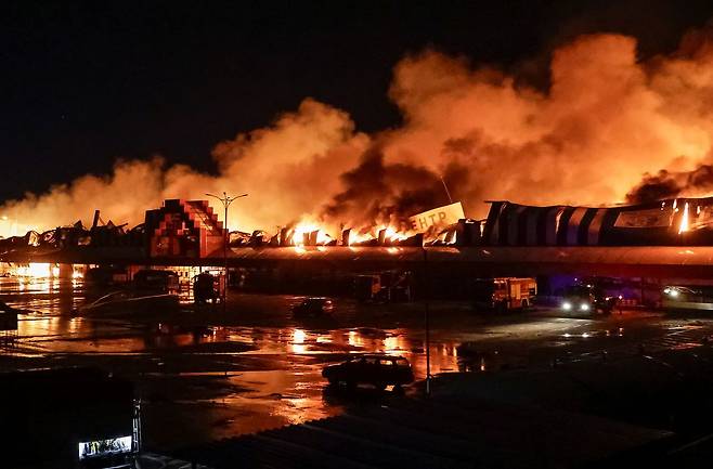 지난 24일 우크라이나 하르키우에서 러시아의 공격이 이어지는 가운데, 러시아의 미사일 공습을 받은 한 생활용품 쇼핑몰 현장에서 소방대원들이 진화 및 수습 작업을 벌이고 있다. [로이터=연합뉴스]