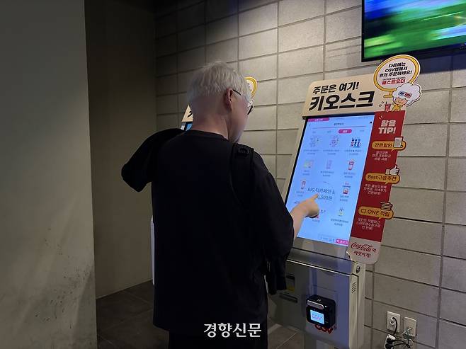 ‘영화의 날’을 하루 앞둔 26일 저시력 시각장애인 최선호씨(44)가 서울 용산구의 한 영화관에서 돋보기 기능을 이용해 음료를 주문하고 있다. 하주언 기자