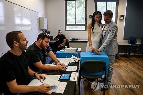 27일 이스라엘 헤르츨리야의 한 투표소에서 이날 저녁 결혼식을 앞둔 신랑 신부가 소중한 한 표를 행사하고 있다.[로이터 연합뉴스. 재판매 및 DB 금지]