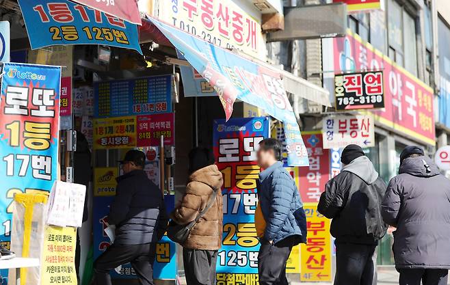 서울 시내 한 복권 판매점에서 시민들이 복권을 구매하기 위해 줄지어 기다리고 있다. [사진 | 뉴시스]