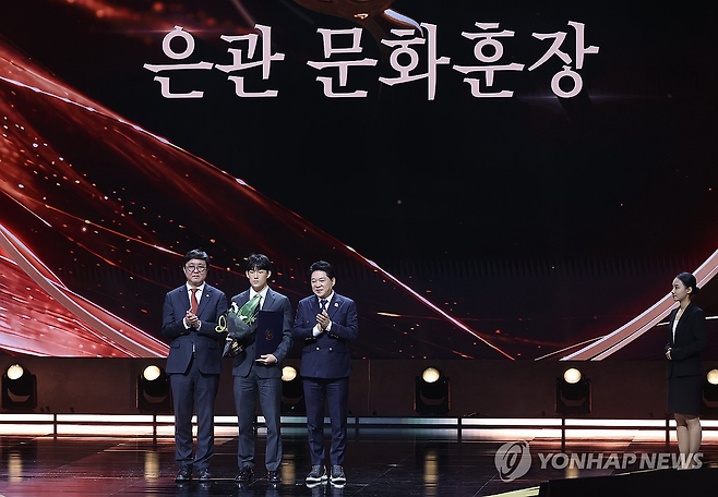 29일 서울 중구 국립극장에서 열린 ‘제17회 대한민국 대중문화예술상’ 시상식에서 은관문화훈장이 추서된 가수 고 신해철의 아들 신동원 씨가 최휘영 문체부 장관(왼쪽)과 기념촬영을 하고 있다. 연합뉴스