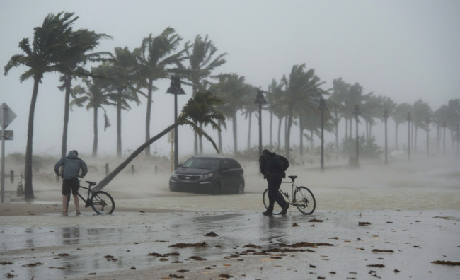 10일(현지시간) 초강력 허리케인 ‘어마’가 미국 플로리다 주에 상륙한 가운데 강풍과 폭우가 몰아치는 포트 로더데일 해안가를 사람들이 힘겹게 걸어가고 있다. 도널드 트럼프 대통령은 이날 플로리다주를 ‘중대 재난지역’으로 선포했다. [포트 로더데일=AP연합뉴스]