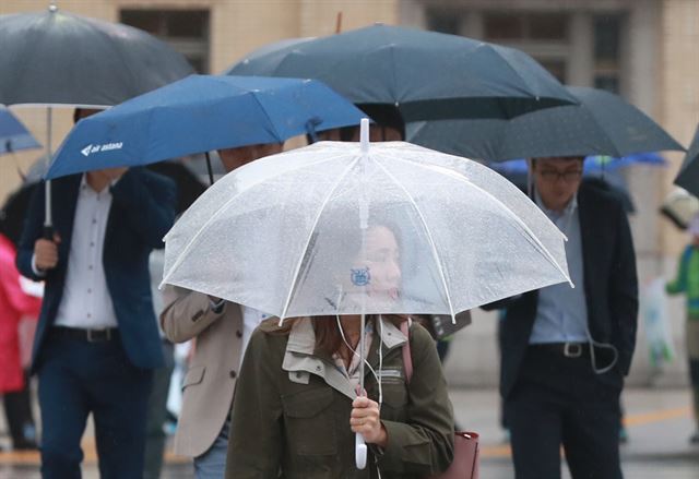 비가 내린 11일 오전 서울 광화문 사거리에서 시민들이 우산을 쓰고 길을 걷고 있다. 연합뉴스
