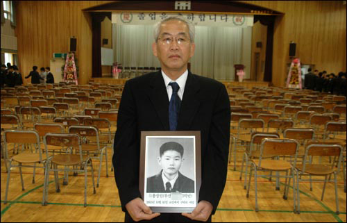 홍권식씨는 2007년 2월 아들 성인군의 영정 사진을 들고 개성중 졸업식에 갔다. [사진 오마이뉴스]