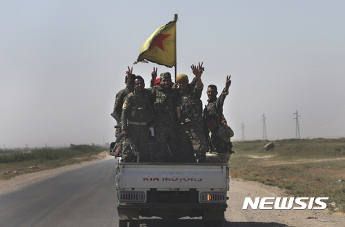 【락까=AP/뉴시스】극단이슬람 무장조직 이슬람국가(IS)의 수도 격인 락까로 연결되는 도로에서 26일(현지시간) 미군의 지원을 받는 시리아자유군(SDF) 군인들이 트럭을 타고 이동하는 동안 손가락으로 승리의 브이(V)자를 만들어 보이고 있다.  2017.07.27