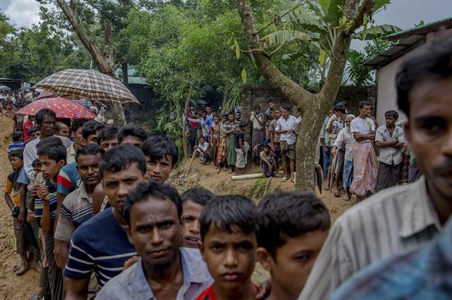 13일 방글라데시 쿠투팔롱 난민촌에 도착한 로힝야 난민들이 임시 대피소를 만들 재료를 보급받기 위해 줄을 서고 있다. 쿠투팔롱=AP 연합뉴스