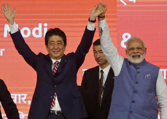 아베 신조(왼쪽) 일본 총리와 나렌드라 모디 인도 총리가 14일(현지시간) 아마다바드에서 진행된 고속철도 착공식에서 손을 들어 인사하고 있다. /AP연합뉴스