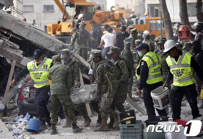 19일(현지시간) 규모 7.1의 강진이 덮친 멕시코 수도 멕시코시티에서 군인과 경찰·소방대원 등으로 구성된 구조대가 생존자 수색·구조 및 피해 복구 작업을 벌이고 있다. © AFP=뉴스1