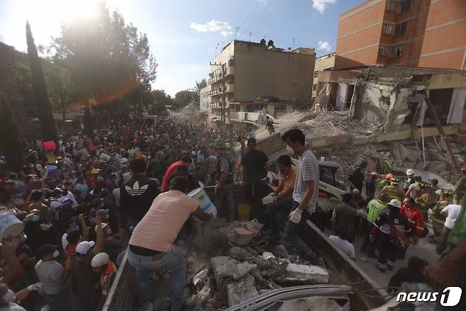 구조대가 19일(현지시간) 멕시코 강진으로 붕괴된 건물을 치우고 생존자를 탐색하고 있다. © AFP=뉴스1