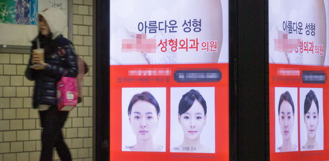 한 여성이 서울의 한 지하철 역사 안에 설치된 성형외과 광고판 앞을 지나가고 있다. 김성광 기자 flysg2@hani.co.kr