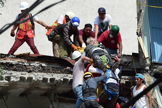 19일(현지시간) 멕시코 수도 멕시코시티에서 지진으로 부상을 당한 한 남자가 구조대에 의해 옮겨지고 있다. /AFPBBNews=뉴스1