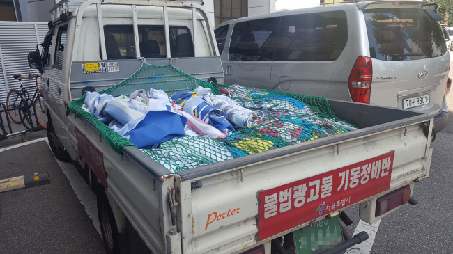 서울시 불법광고물기동정비반이 운행하는 흰색 트럭 짐칸 모습. 하루종일 제거한 불법 현수막이 가득 쌓여있다.