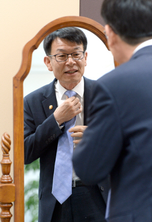 김상조 공정거래위원장이 인터뷰에 앞서 넥타이를 만지고 있다.