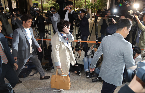서 씨(가운데)가 12일 오후 서울경찰청 로비에서 몰린 기자들을 지나 조사실로 향하고 있다.