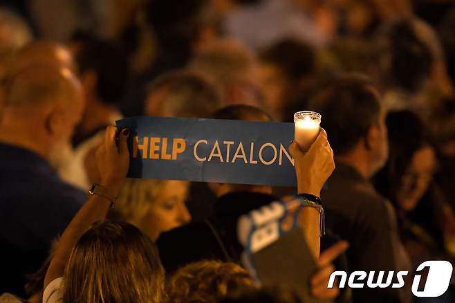 한 바르셀로나 여성이 "카탈루냐를 도와달라"는 피켓을 들고 있다. © AFP=뉴스1