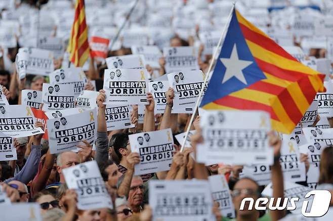 카탈루냐 독립을 지지하는 시민들이 카탈루냐 독립기를 흔들며 시위하고 있다. 스페인 중앙정부는 21일(현지시간) 카탈루냐 자치정부를 해산하고 6개월내 지방선거를 실시하겠다고 발표했다. © AFP=뉴스1
