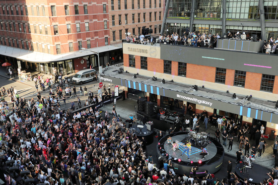 삼성전자는 지난해 6월  미국 뉴욕 마케팅 센터인 ‘삼성837’에서 웨어러블 기기 ‘기어 핏2’와 ‘기어 아이콘X’를 공개했다. 삼성 837에 모인 1500여명의 참석자들이 유명 DJ 디플로의 공연을 관람하고 있다. © News1