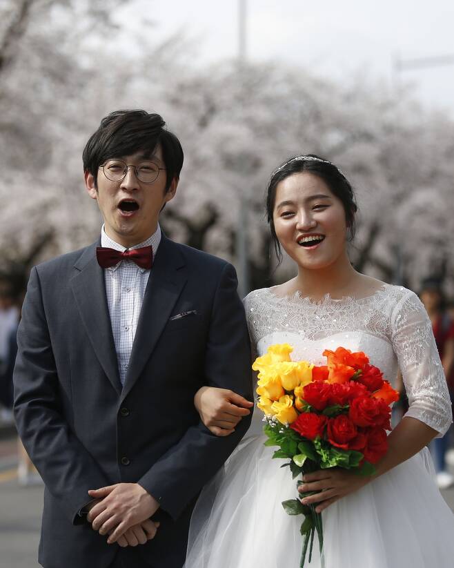벚꽃축제가 한창이던 지난 4월9일 서울 여의도에서 양복과 웨딩드레스를 차려입은 두 사람이 활짝 웃고 있다.
