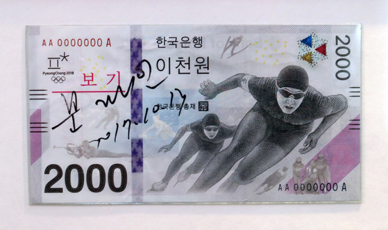 한국은행은 평창 동계올림픽에서 처음으로 2000원 기념은행권 발행했다. 왼쪽에 문재인 대통령의 친필서명이 보인다.앞면에는 스피드스케이팅 선수들의 모습이 등장한다. 최승식 기자