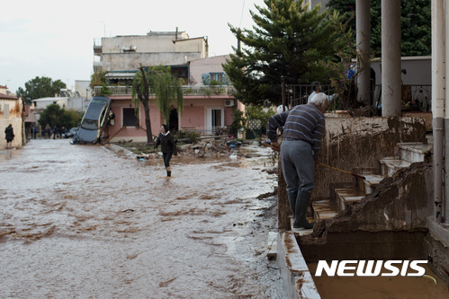 【만드라=AP/뉴시스】그리스 노인이 15일(현지시간) 홍수가 발생한 수도 아테네 서부 외곽도시 만드라에서 진흙투성이가 된 집 앞을 치우고 있다.  2017.11.16