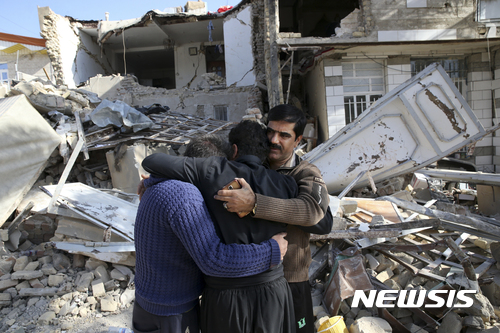 【사르폴 에 자하브=AP/뉴시스】 이란 일가족이 15일(현지시간) 서부 사르폴 에 자하브에서 무너진 주택 앞에서 서로 안고 슬퍼하고 있다. 2017.11.17