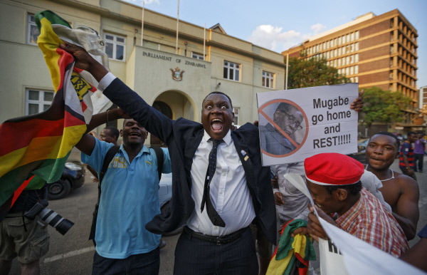 짐바브웨 수도 하라레의 의회 건물 앞에서 21일(현지시간) 로버트 무가베 사임 소식을 들은 시민들이 환호하고 있다. 하라레|AP연합뉴스