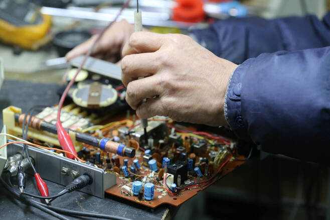 한 수리 장인이 고장난 전자제품의 회로판을 점검하고 있다. . 신인섭 기자