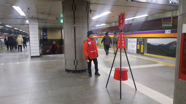 [사진=지난 8일 오후 종로3가 지하철역에서 구세군 자선냄비 자원봉사를 하고 있는 이재선(58ㆍ여) 씨의 모습. 그는 올해 기부 분위기는 어느 때보다 싸늘하다고 걱정했다.]