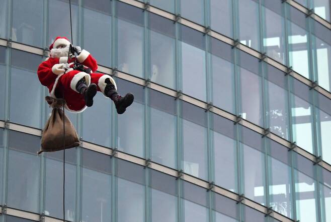 17일(현지시간) 독일 베를린 콜호프타워에서 줄을 타고 내려오며 매년 크리스마스 시즌에 실시하는 곡예시범을 선보이고 있다.[AFP=연합뉴스]
