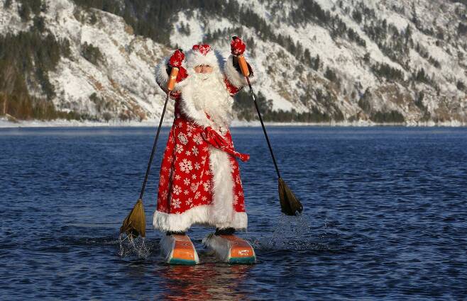 19일(현지시간) 러시아 크라스노야르스크 지방의 예니세이강에서 니콜라이 바실리 에프(64)가 러시아의 산타클로스인 프로스트 복장을 하고 물 스키를 타고 있다.[로이터=연합뉴스]