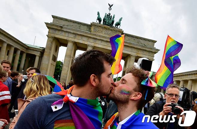 지난 6월 독일 연방하원에서 동성결혼 합법화 법안을 가결하자 한 동성 커플이 베를린 브란덴부르크문 앞에서 입을 맞추고 있다. © AFP=뉴스1