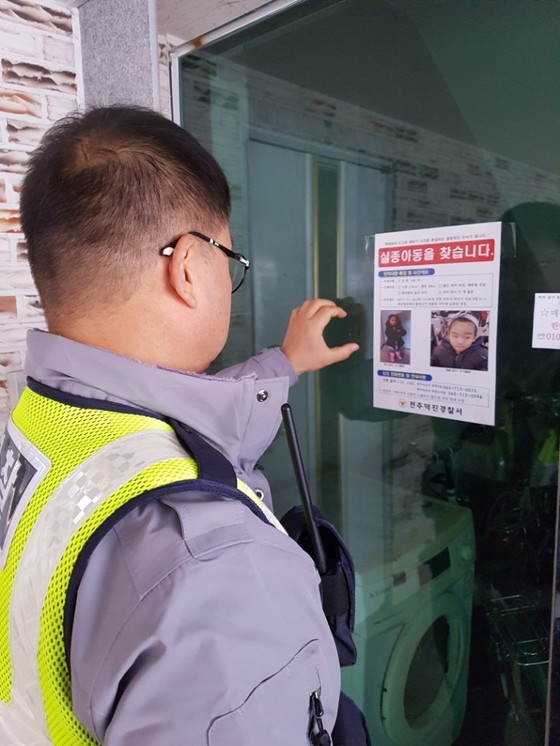 한 경찰관이 고준희(5)양을 찾는 전단을 원룸 앞에 붙이고 있다. 김준희 기자
