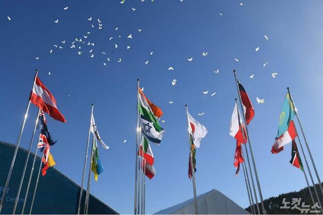1일 오후 강원도 평창동계올림픽 선수촌에서 열린 개촌식에서 만국기 뒤로 평화의 비둘기 풍선이 날아가고 있다. (사진=이한형 기자)