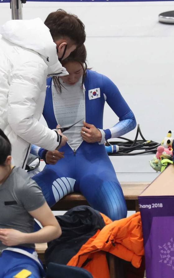 이상화가 코치의 도움을 받아 새 선수복을 입고 있다. 오종택 기자
