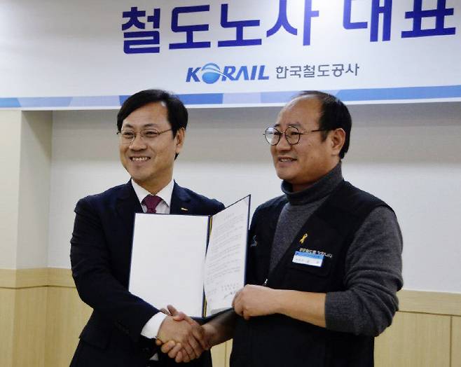 오영식 코레일 사장(왼쪽)과 강철 철도노조 위원장이 8일 대전 코레일 본사에서 해고자 98명의 복직 합의문을 들고 악수하고 있다.|철도노조 제공