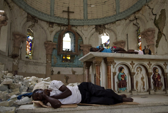 2010년 1월 대지진으로 삶의 터전을 잃은 아이티 이재민들이 수도 포르토프랭스의 부서진 산타 아나 교회에서 잠을 청하고 있다. [AP=연합뉴스]