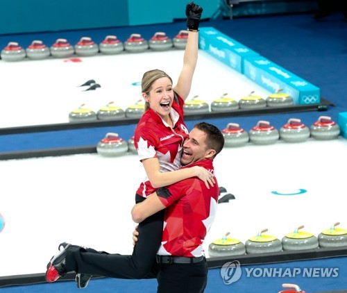 올림픽 최초의 믹스더블(혼성 2인조) 컬링 금메달리스트가 된 캐나다의 케이틀린 로스(왼쪽)와 존 모리스가 기쁨을 나누는 모습. [EPA=연합뉴스]