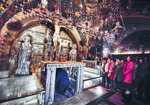 성지 순례객들이 지난 16일 예루살렘 성묘교회 내 예수님이 십자가에 못 박힌 곳으로 추정된 장소에서 참배하고 있다. 새에덴교회 제공