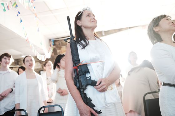 하얀 웨딩드레스를 입은 한 신부가 자신의 AR-15 총을 들고 합동결혼식에 참석했다. [EPA=연합뉴스]